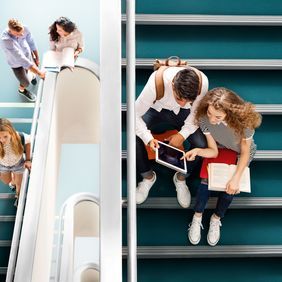 Green safety flooring on a college staircase with people seating down 