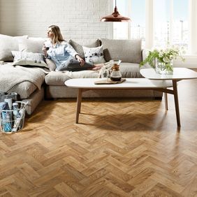 Oak parquet wood effect flooring in living room with a cream sofa and coffee table