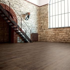 Large room with open brick walls featuring dark brown wood effect flooring 