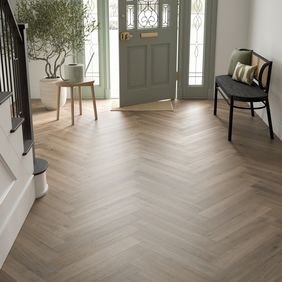 Oak effect flooring laid in a herringbone style in a large hallway