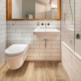 Light oak wood effect flooring in a modern style bathroom 