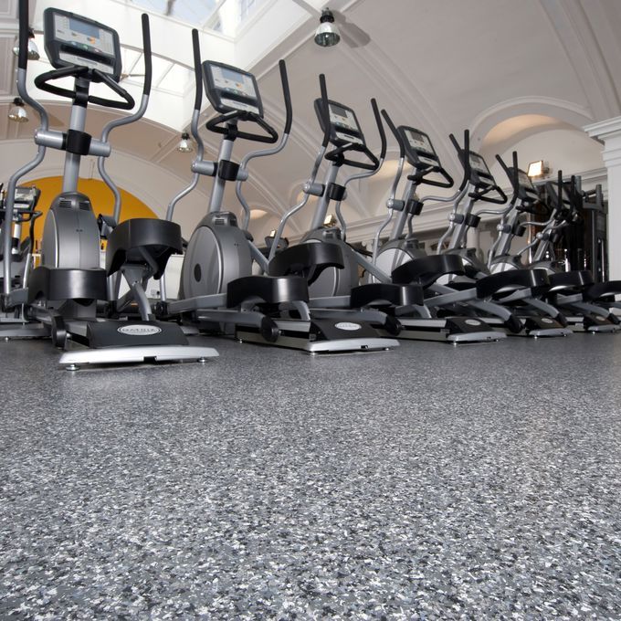Gym studio with bike machines and dark coloured flooring