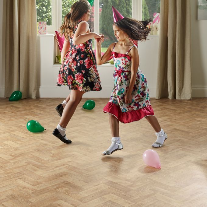 Light wood effect flooring in a parquet design with two girls dancing 