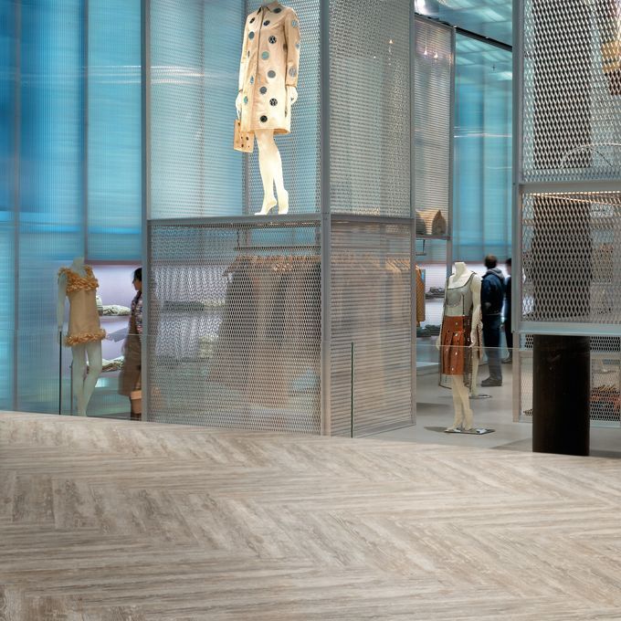 Retail shop with mannequin displaying a dress with pine flooring laid in a herringbone design 