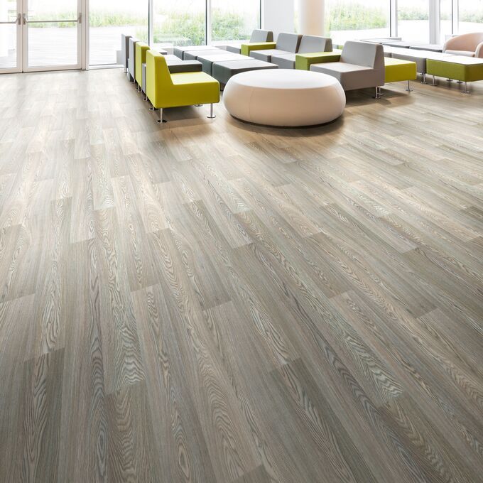 Timber effect flooring laid in a large waiting area with seating
