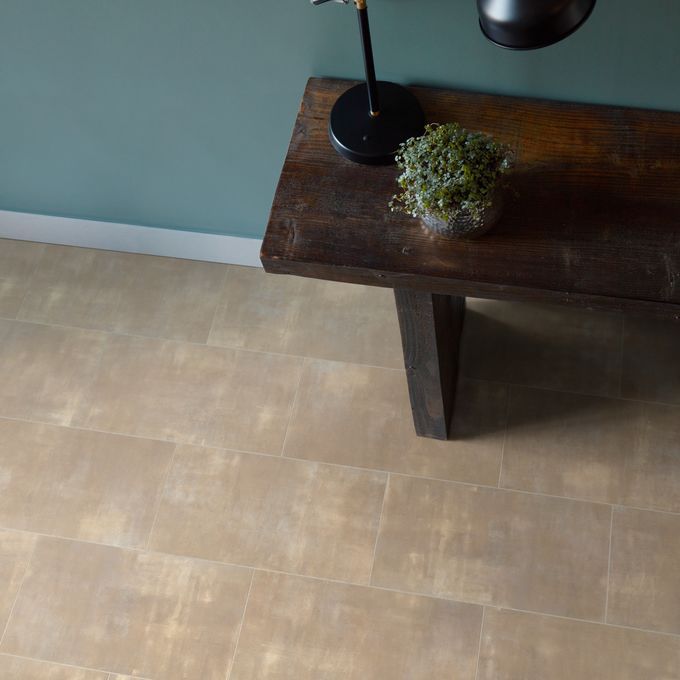 Close up of light stone effect tile flooring with dark oak wood side table 