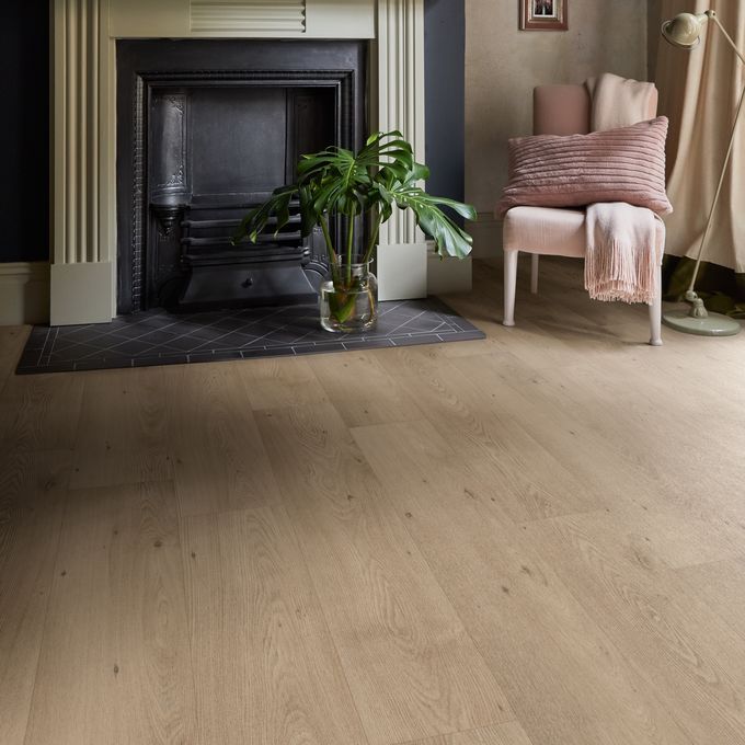 Oak effect flooring in a room with an open fireplace and navy walls