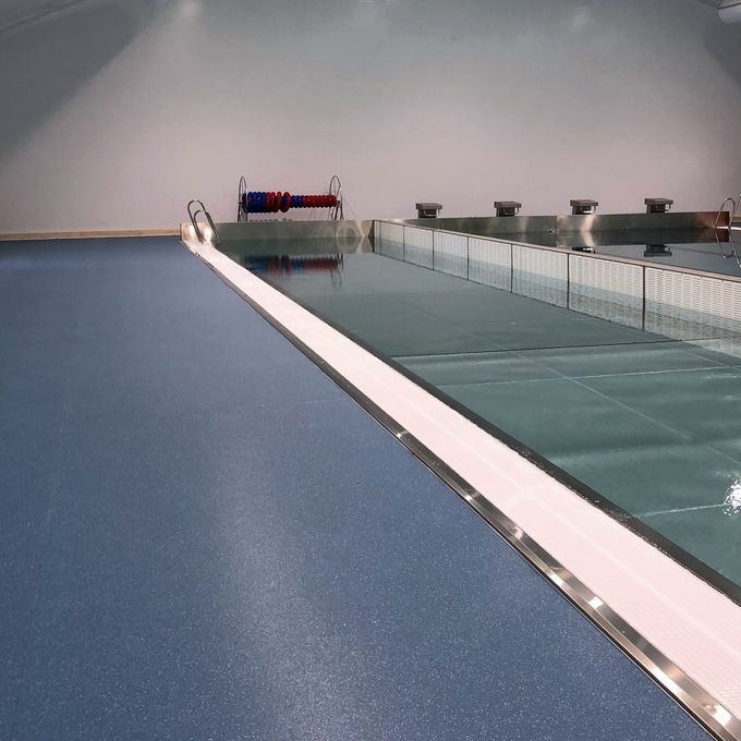 Dark blue flooring at the side of public swimming bath