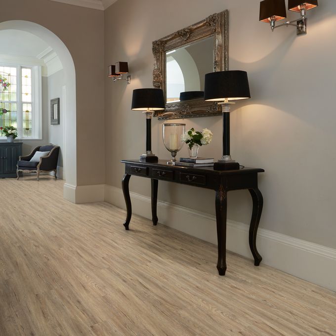 Hallway with dark wood console and lamps featuring light wood effect flooring in Quayside Oak 
