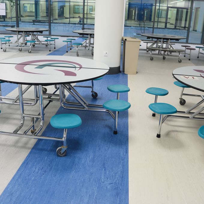 Blue homogeneous laid beside a grey homogeneous floor in a student canteen 