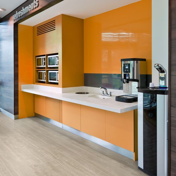 Light oak wood effect flooring in a refreshment area with orange walls 