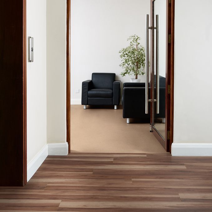 Office corridor with black leather chairs for seating area with walnut effect flooring laid alongside Pearlazzo PUR