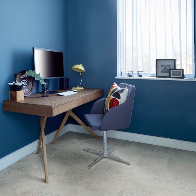 Home desk with computer and chair featuring a light concrete effect flooring 