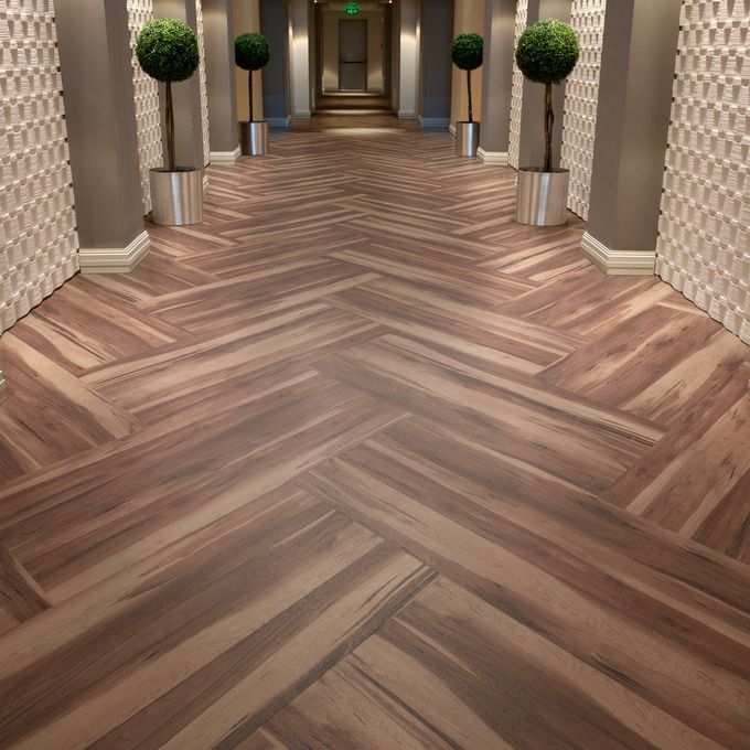 Corridor with plants and walnut effect flooring laid in a Herringbone pattern 