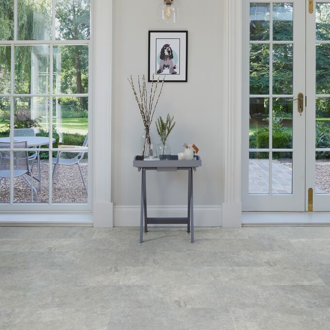 Side table, large framed windows, picture, cement style tile floor 
