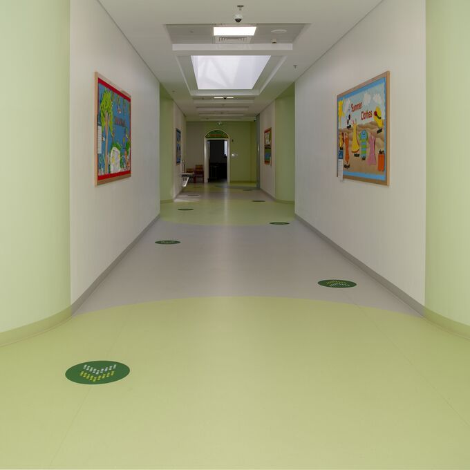 Hospital corridor with light grey and green Polyflor flooring