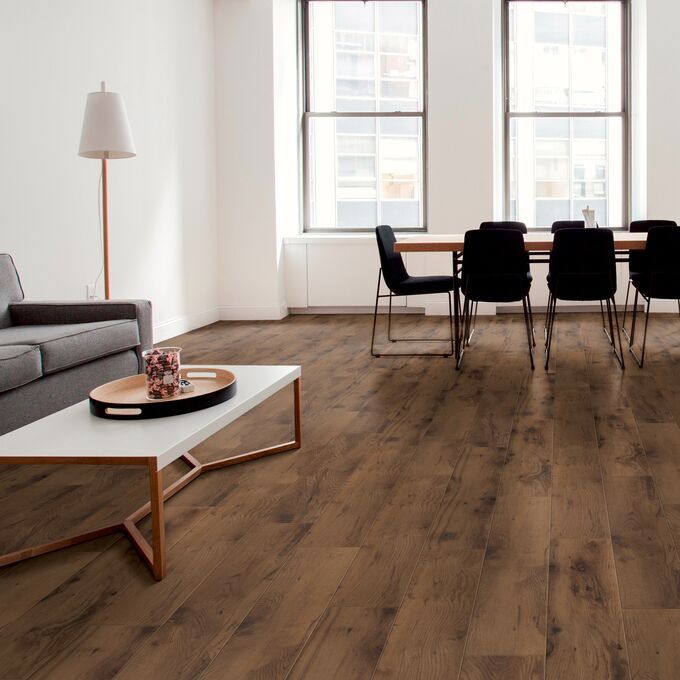 Dark coloured oak effect flooring laid in an apartment open plan living space
