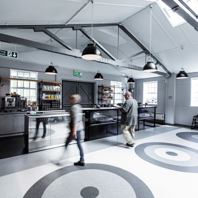 Various shades of grey coloured flooring to create a circle design floor in a canteen area 