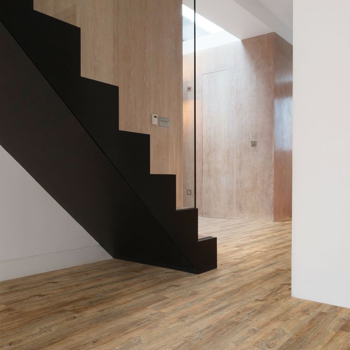 Modern black staircase with glass panelling and rustic effect flooring 
