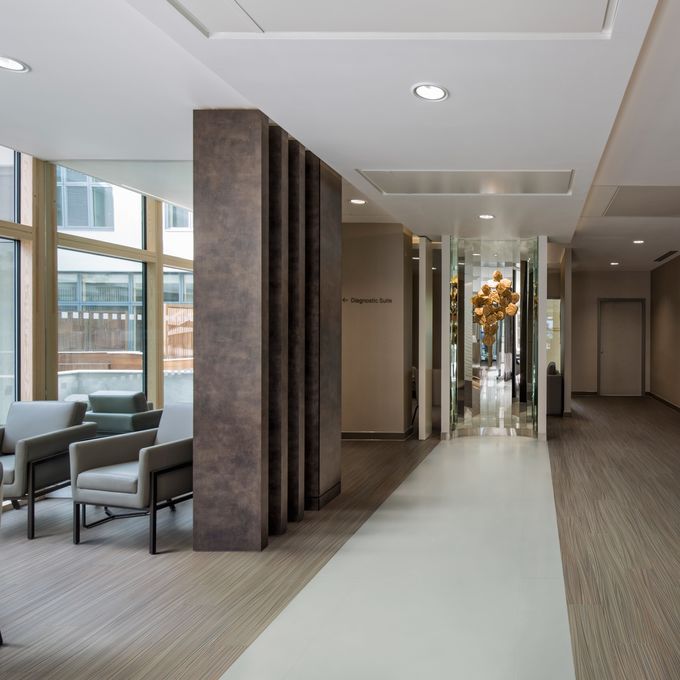 Light concrete effect flooring laid alongside oak effect flooring to create a walkway and seating area