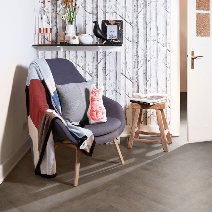 Smoked wood effect flooring in a herringbone design featured in a cosy reading corner in a residential home