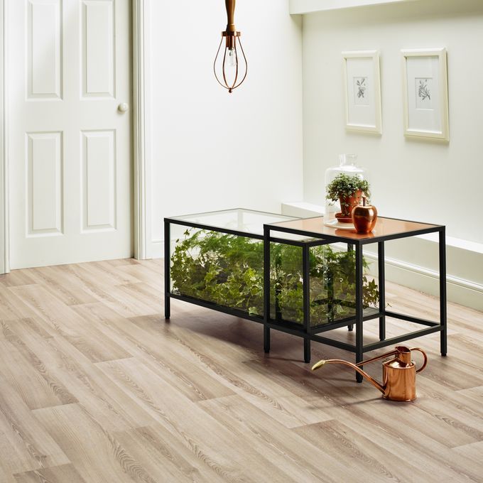 Light oak wood effect flooring in a home with table and plants 