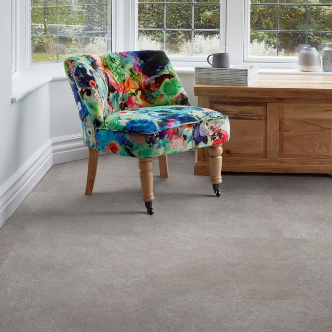 Window area with colourful armchair and Concrete effect flooring 