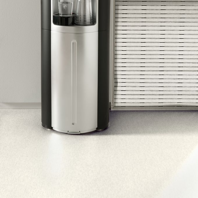 White stone effect flooring in a waiting area with a water cooler