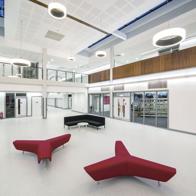 Pale grey flooring in a large waiting area in a highschool 