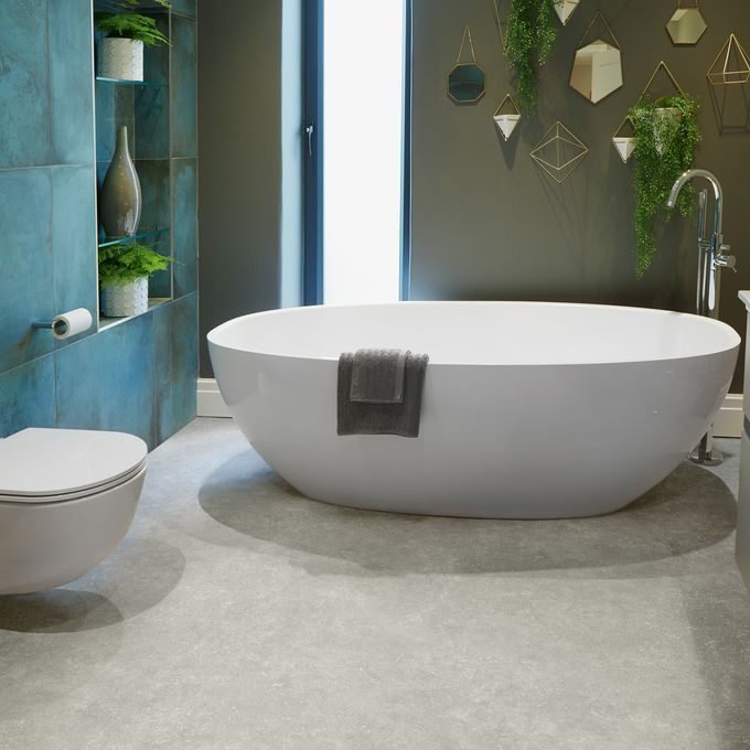 Cement effect flooring laid in a bathroom with greenery on the walls