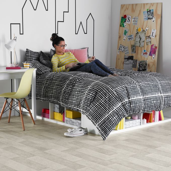 Grey Limestone effect flooring in a bedroom with a girl reading on her bed