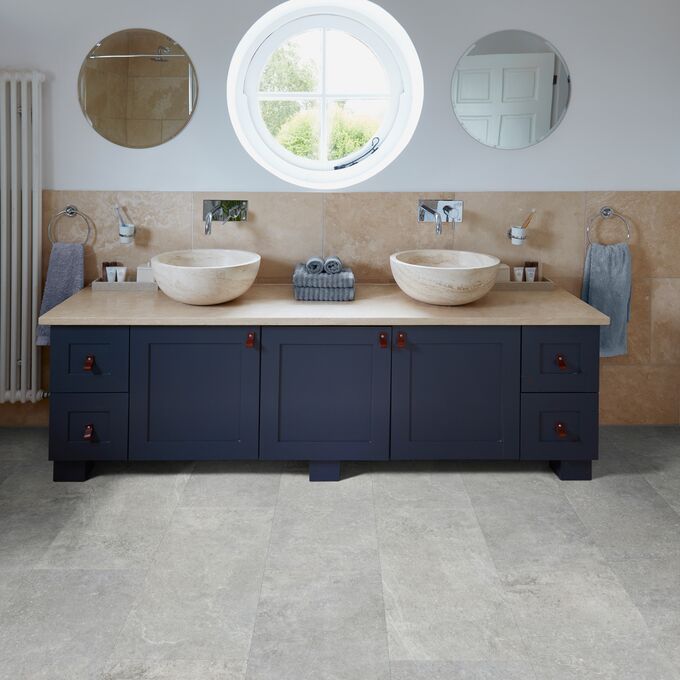 Bathroom, twin sinks, hand towels, mirrors, cement style tile floor 