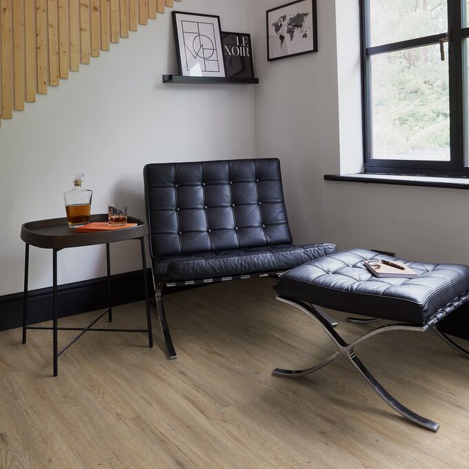 Seating area, leather chair, foot rest, wood panel wall, oak style flooring 