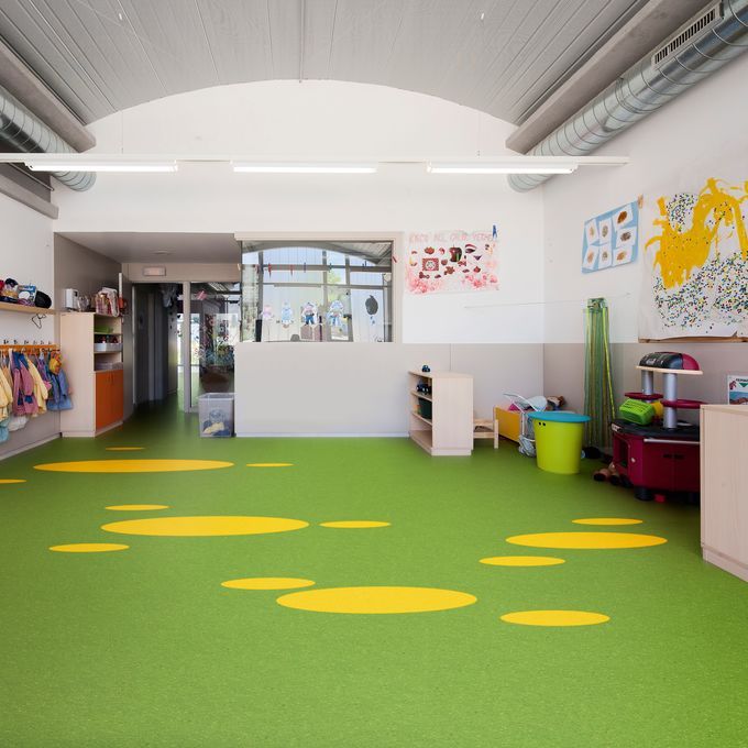 Green flooring with yellow circles in a nursery play room