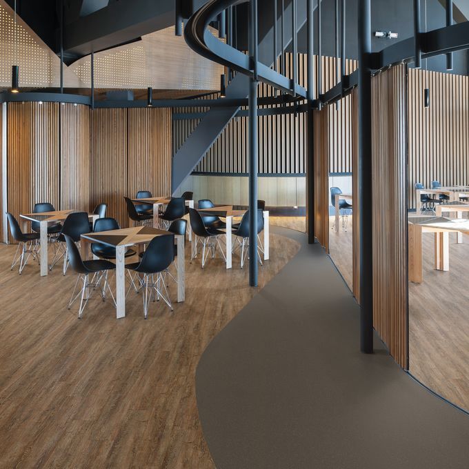 Canteen area with dining tabels and chairs, Huckleberry oak flooring laid alongside Exopna Flow Taupe 