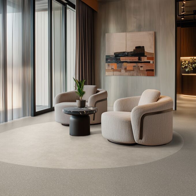 Light coloured cement effect flooring laid in a hotel lobby seating area