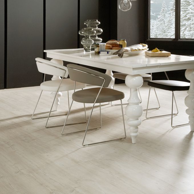 White dining table with chunky table legs with white oak wood pattern flooring 