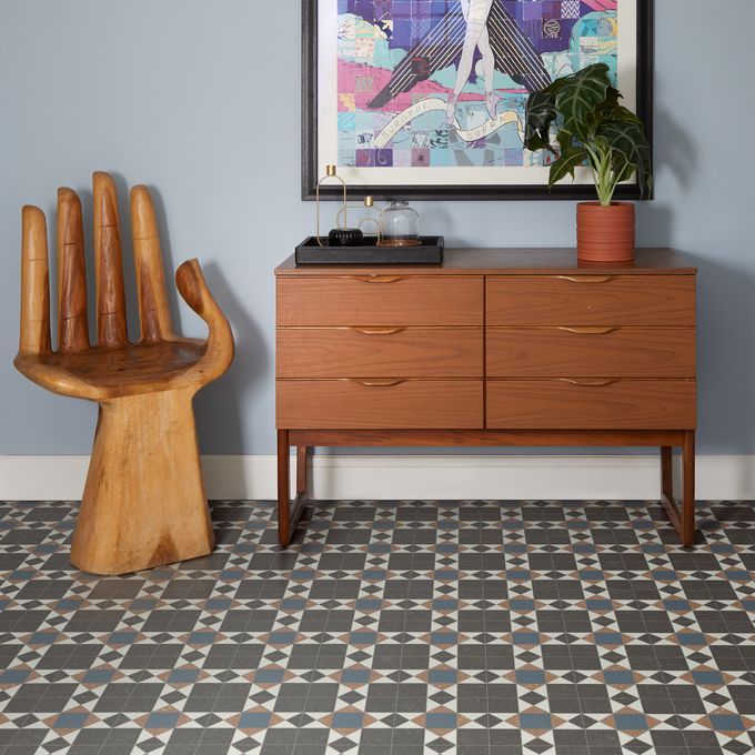 Tiled effect LVT in a hallway with abstract art on the walls and obscure hand chair
