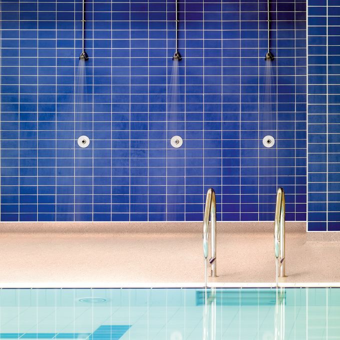 Swimming pool shower area with neutral coloured walkways