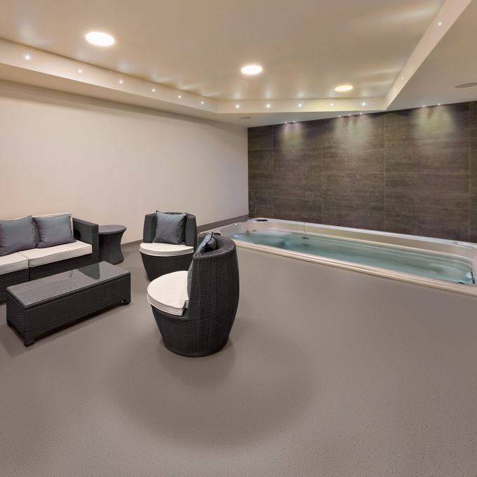 Brown colour safety flooring in a spa relaxation area with seating and hot tub