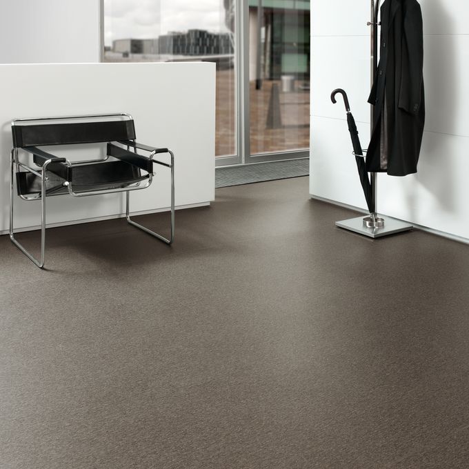 Dark stone effect safety flooring in a waiting area with cloakstand