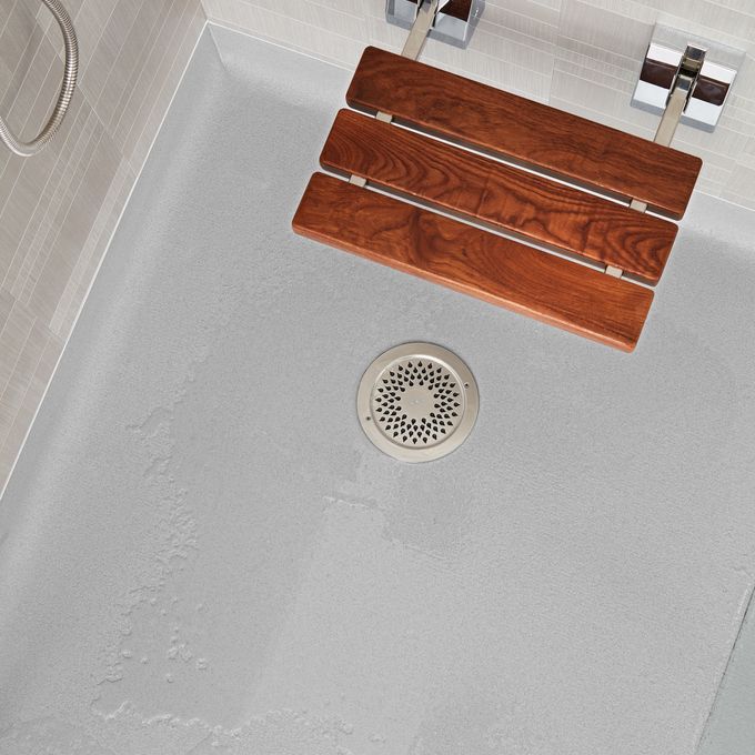 Light coloured safety flooring in a wak in shower with seat
