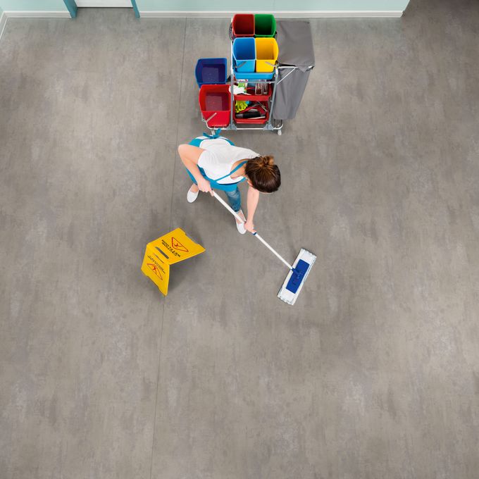 Overhead of a lady cleaning a concrete effect flooring