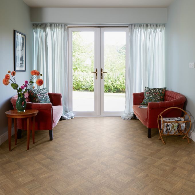 Basket weave style flooring in a sitting room with patio doors and an orange couch