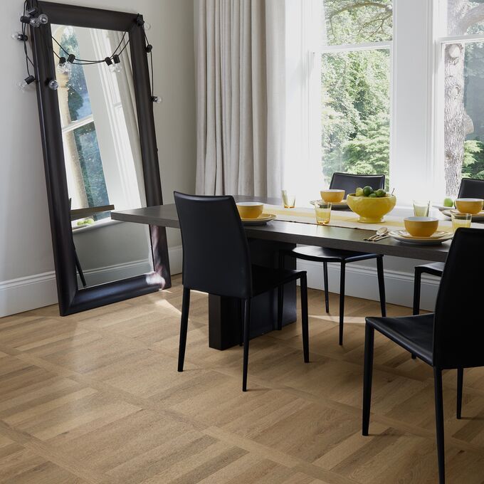 Oak effect flooring laid in a residential dining area with a table and chairs