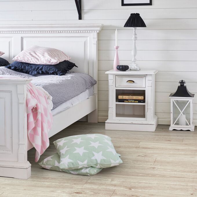 Oak effect flooring laid in a bedroom with white panelled walls