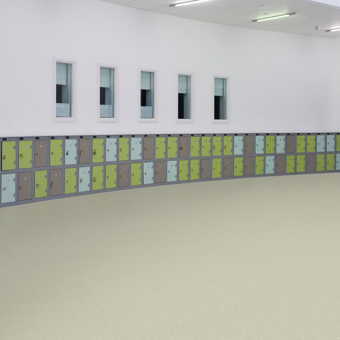 Neutral colour safety flooring in a large open space with lockers 