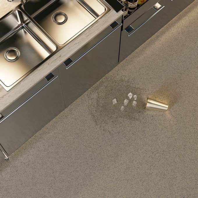 Overhead shot of a commercial kitchen with a spilled drink on the dark coloured floor