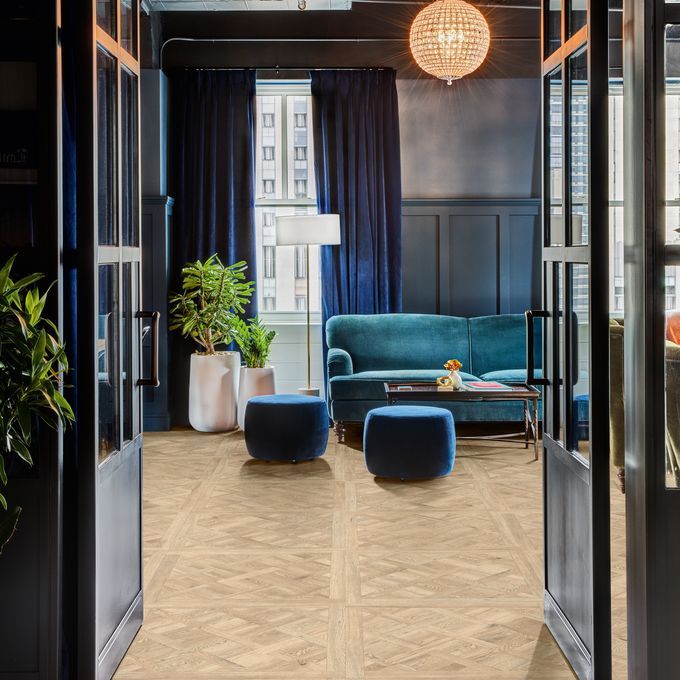 Oak effect flooring flowing from the hallway into the front room with navy decor