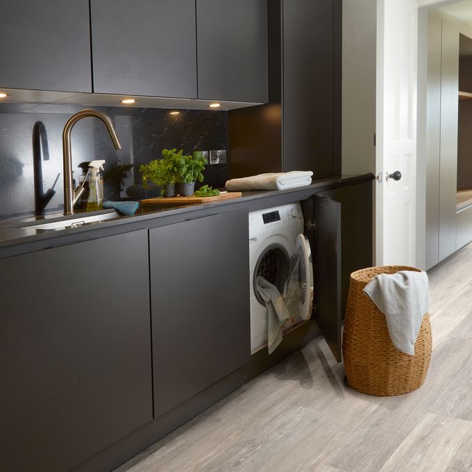 Oak effect flooring in a modern kitchen with matt black units